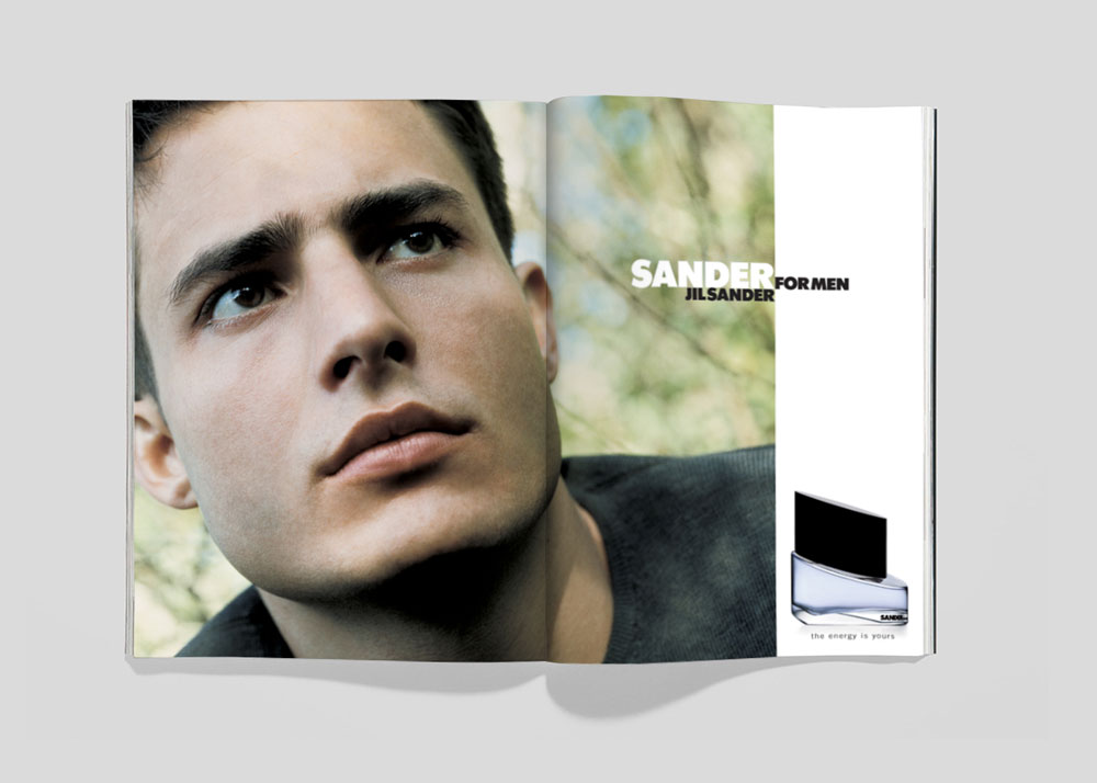 Jil Sander for Men magazine advertisement featuring a portrait of a man's face and a bottle of cologne on a double-page spread.