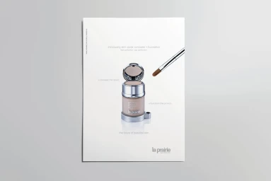 Cosmetic jar with an open compact lid and a makeup brush angled beside it against a clean white background.