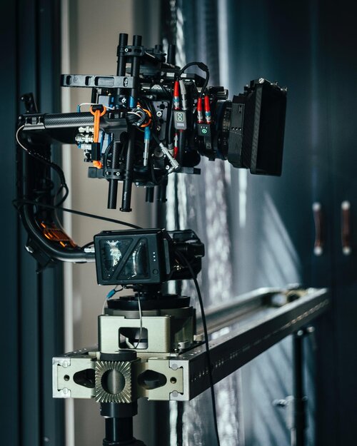 Professional broadcast camera on a track, indoors. Complex camera rig for video production with cables, monitor, and gear system.