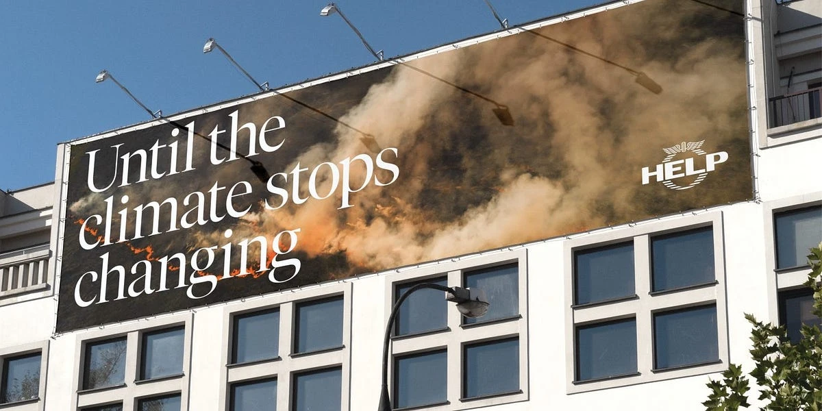 Billboard on a building featuring a climate change message with smoke and fire imagery, and the word HELP in white letters.