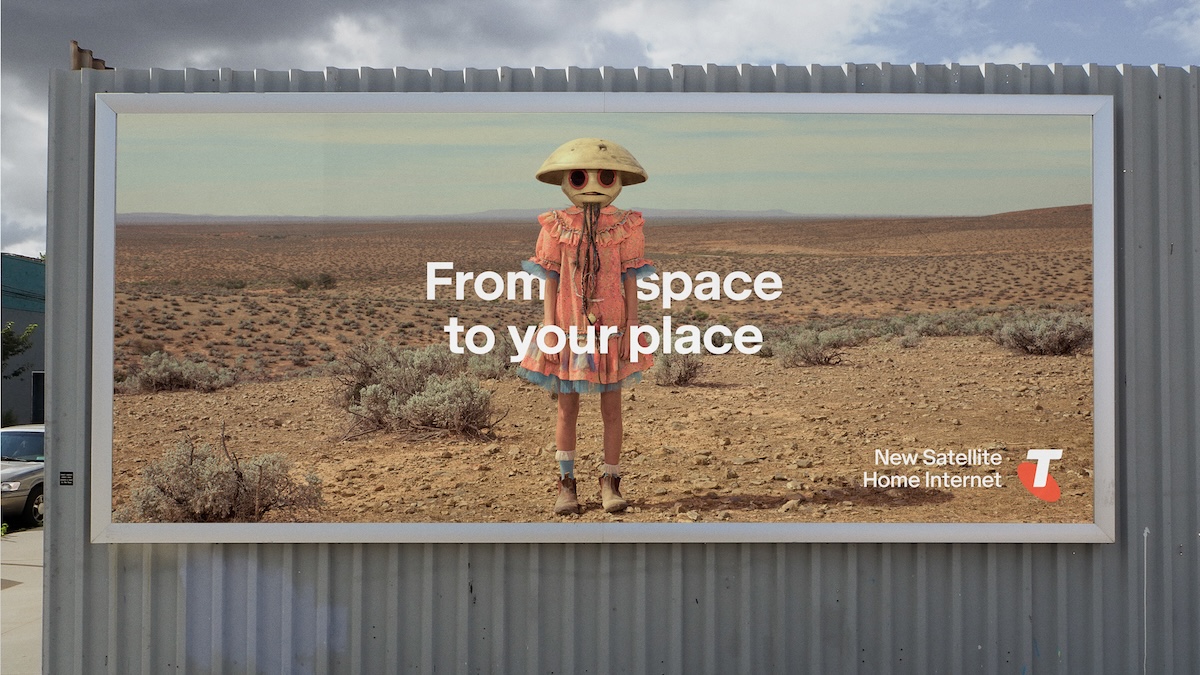 Billboard advertisement with a person in a costume standing in a desert landscape and the words 'From space to your place'.