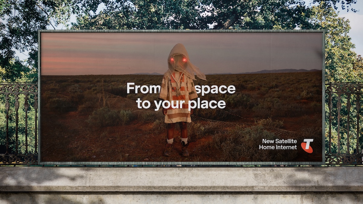 Billboard in an outdoor setting showcases a child with glowing eyes in a desert landscape advertising new satellite home internet.