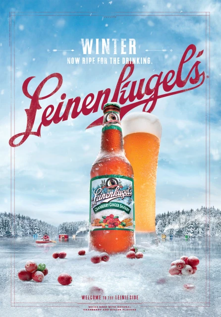 Leinenkugel's cranberry ginger shandy advertisement featuring a bottle of the beverage with a glass of beer set on a snowy landscape.