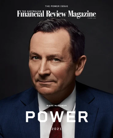 Portrait of Mark McGowan wearing a blue suit, white shirt, and red tie against a dark grey background.