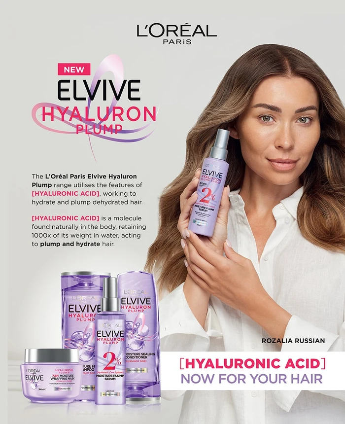 Woman holding a purple hair serum bottle with L Oreal Elvive Hyaluron Plump product range displayed on a white background