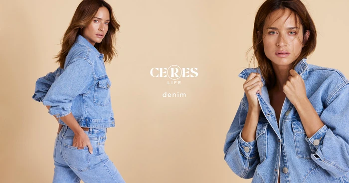 Woman wearing light blue denim jacket and matching jeans against a warm neutral studio background, photographed by Marija Ivkovic.