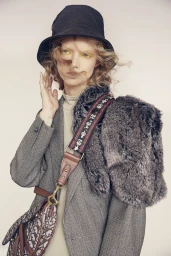 Model in black bucket hat and grey blazer wearing patterned handbag photographed by Lauren Schulz