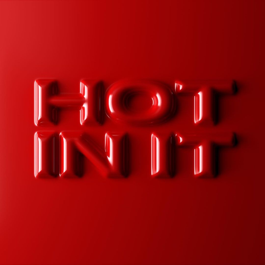 Close-up of red, embossed lettering that spells out 'HOT IN IT' against a matching red backdrop creating a glossy monochromatic graphic.