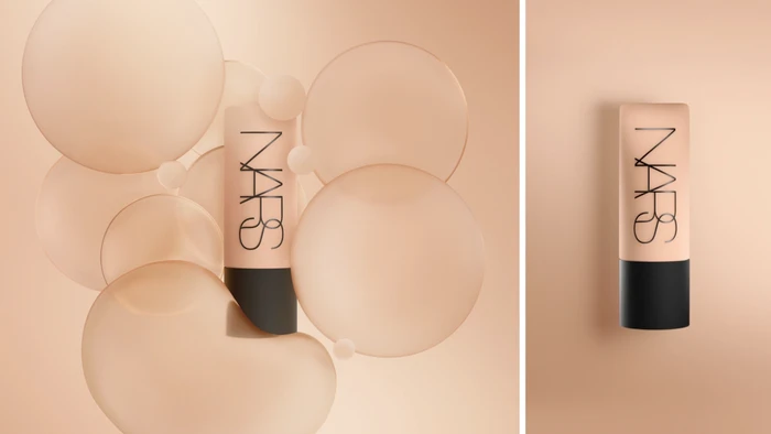 NARS foundation bottle surrounded by translucent glass spheres on a warm nude gradient background by Leo+Nick.