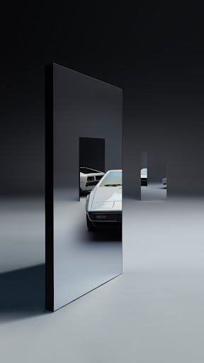 Two vintage cars are visible through rectangular mirrored panels in a minimalist automobile studio with dark grey and light grey surfaces.