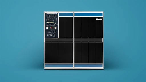 Vintage computer mainframe with black panels and blue trim against a blue background, showcasing retro technology and minimalist design.