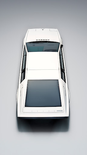 Overhead studio shot of a sleek, white vintage Lotus Esprit sports car with a black rear panel against a neutral gray backdrop.