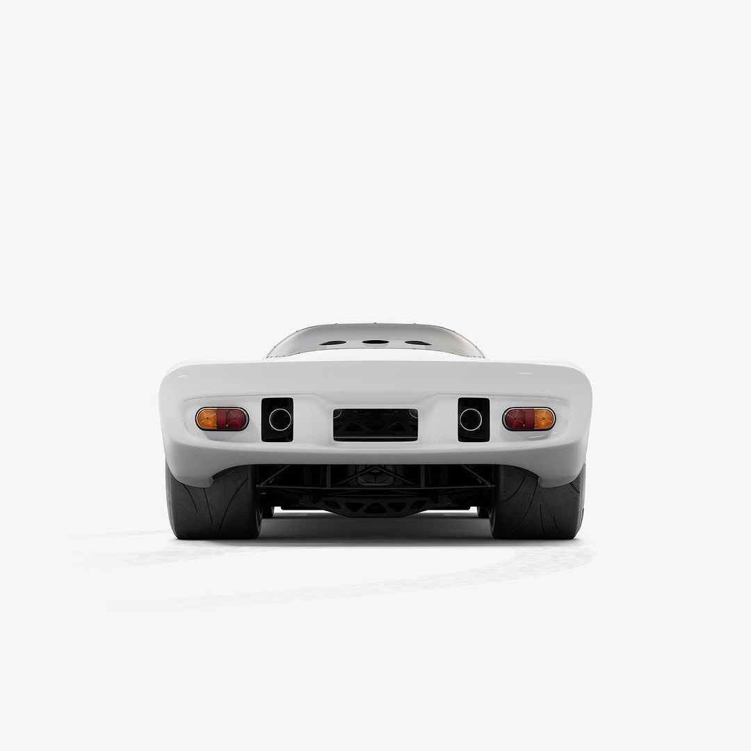 Rear view of a matte white sports car isolated on a white background with visible tires, exhaust pipes, and taillights.