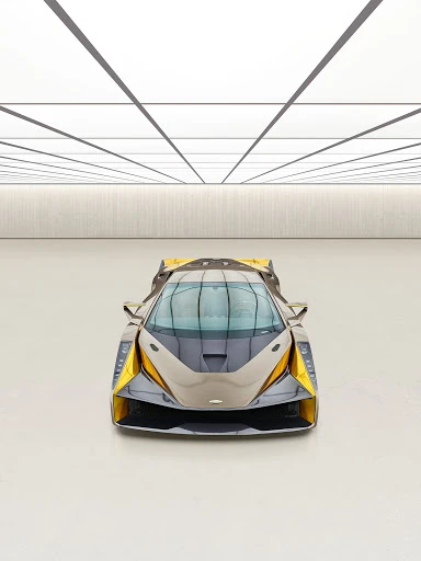 Frontal view of a grey and yellow sports car with a sleek design in an indoor auto studio with a glossy white floor and ceiling.