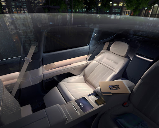 Luxury car interior featuring white leather seats, a sleek console with a digital display, and a comfortable, high-end design aesthetic.
