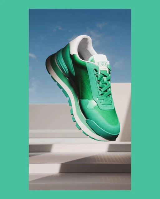 Green and white Liu Jo sneaker on a white surface with a blue sky background. Fashionable athletic footwear for style and comfort.