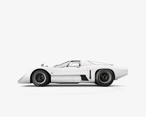 Profile view of a white vintage race car with black wheels against a plain white background