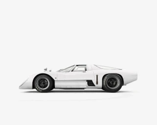 Profile view of a white vintage race car with black wheels against a plain white background