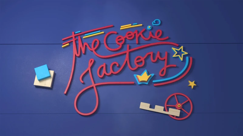 Whimsical animation of 'The Cookie Factory' logo with colorful lettering, a toy-like crown, stars, and geometric shapes on a blue background.