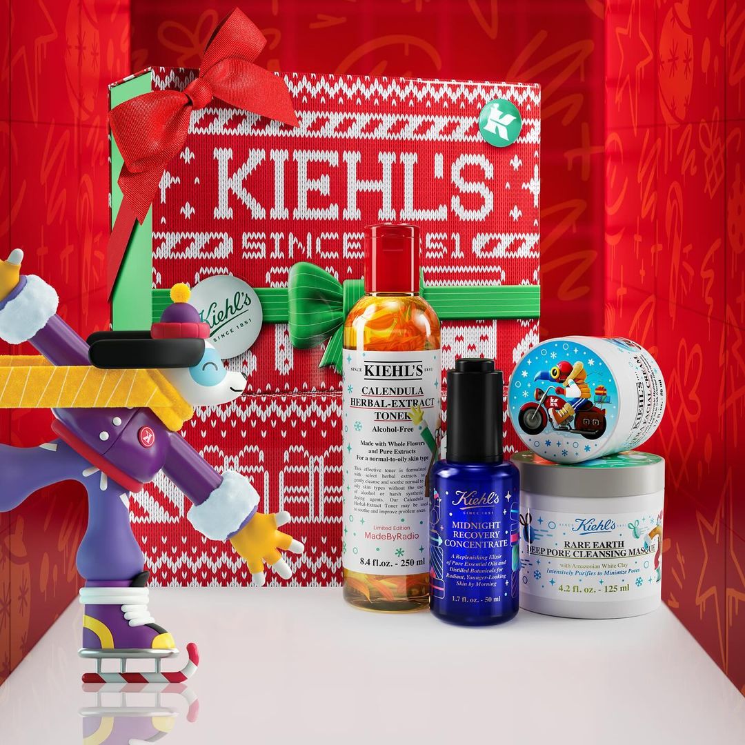 Kiehl's skincare products displayed in a festive holiday box with a toy figure, showcasing a variety of toners, serums, and masks.