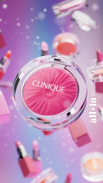 Close-up of pink Clinique blush floating among various makeup containers against a colorful gradient background.
