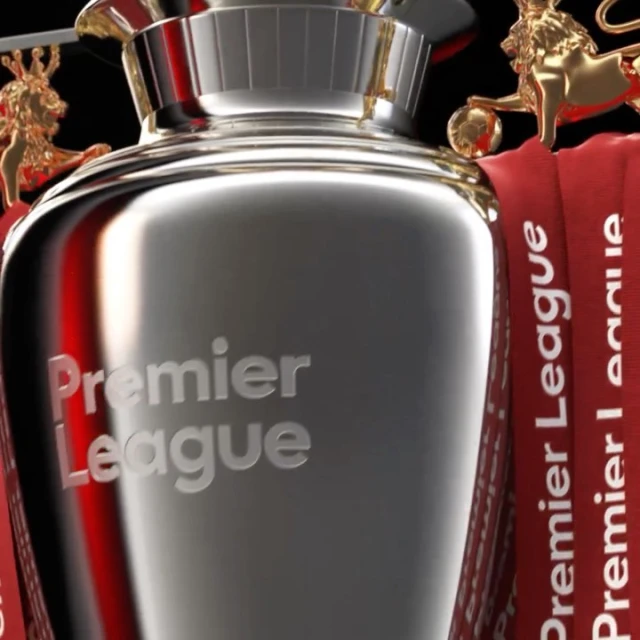Close-up of Premier League trophy with gold lion statues and branded ribbons. Sports and championship theme with metal textures.