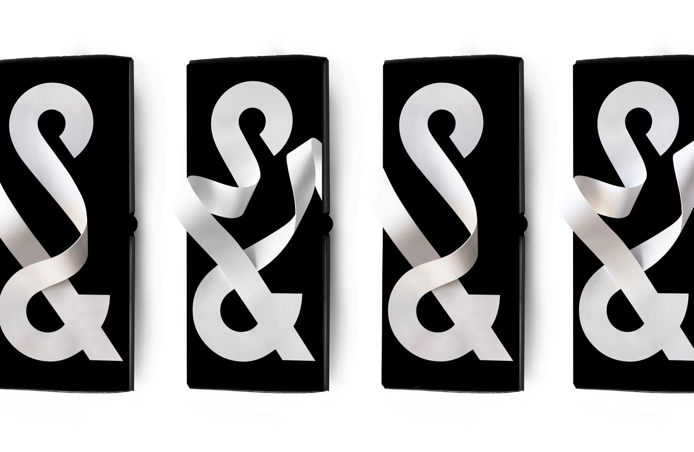Four black and white ampersand art pieces in a row, creating a pattern with flowing ribbons on a white background.