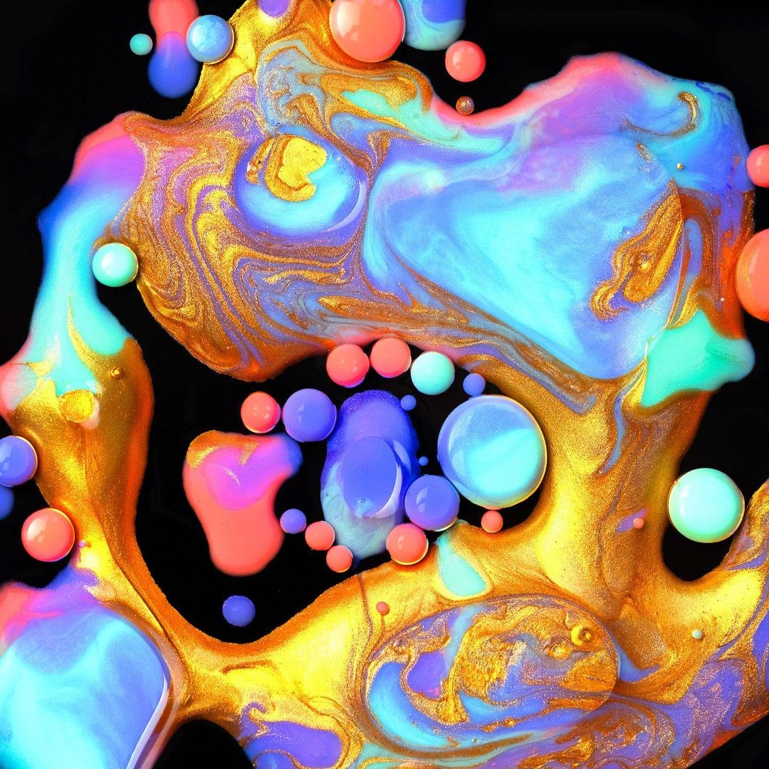 Abstract background with mixed colorful paint swirls and spheres in shades of blue, pink, orange, and gold against black backdrop.