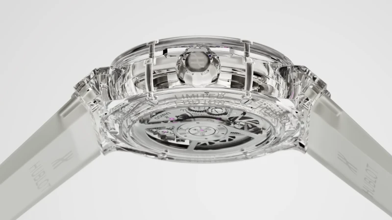 Transparent Hublot watch with visible movement, showcasing intricate mechanics and design against a clean, bright background, luxury timepiece.
