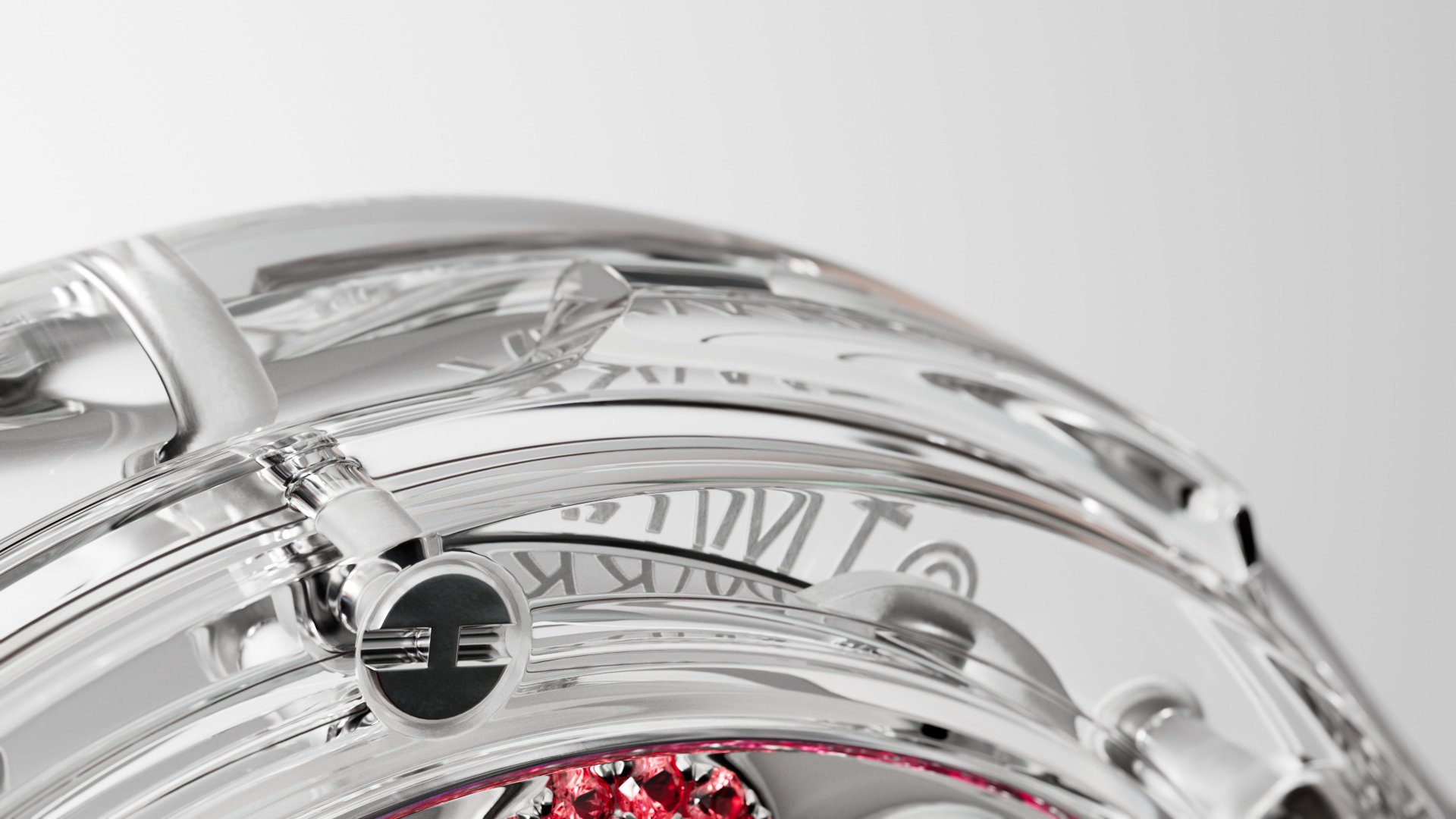 Close-up of a transparent sphere with metallic structures and red jewels, set against a clean, bright background, showcasing its intricate design.