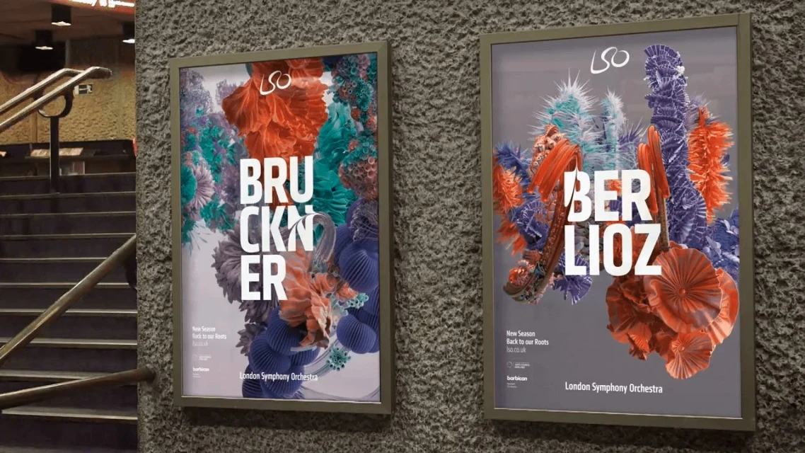 Two framed posters on a textured gray wall promote London Symphony Orchestra's new season with coral, blue, and green abstract designs.