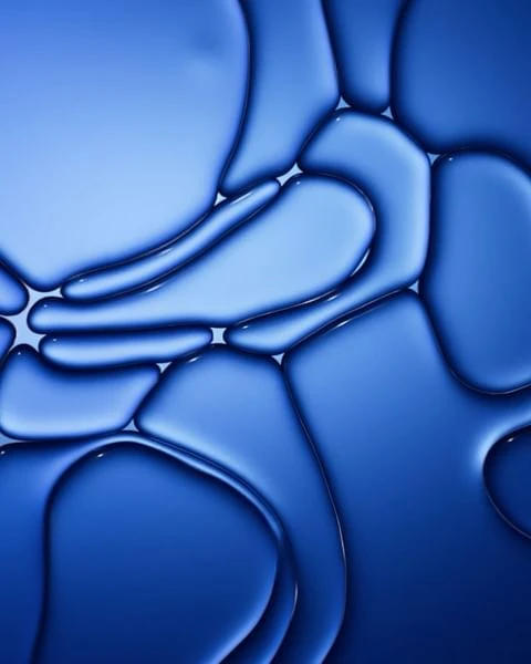Abstract close-up of connecting blue fluid shapes and forms creates a bubbly effect, featuring smooth gradient transitions.