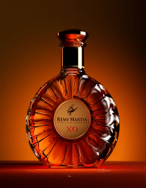 Luxury Rémy Martin XO Cognac Fine Champagne bottle, studio shot with warm amber lighting, product photography, premium alcohol beverage.