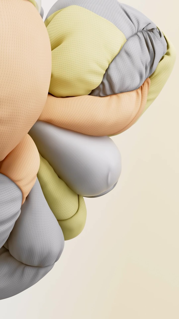 Abstract close-up of a three-dimensional plush structure with pastel gray, yellow, and orange sections against a pale background.