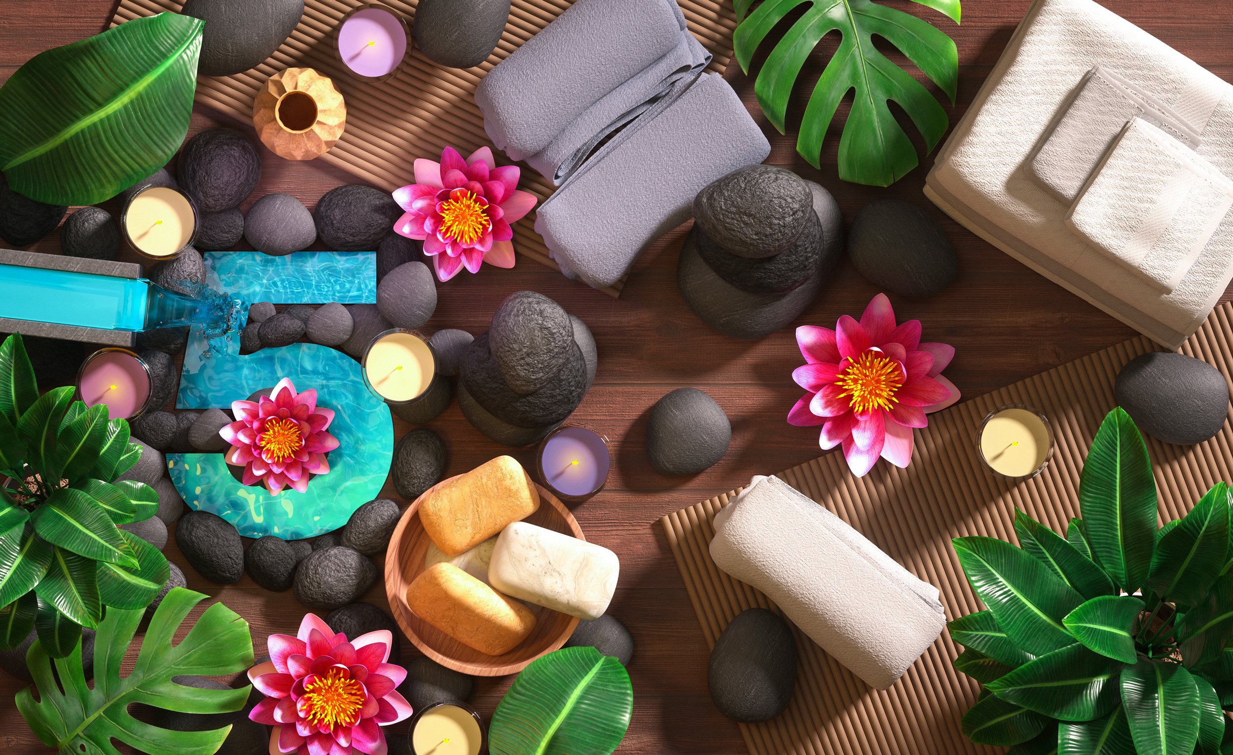 Still life composition featuring spa and wellness elements: stones, towels, pink water lilies, candles, and green leaves on wooden surface.