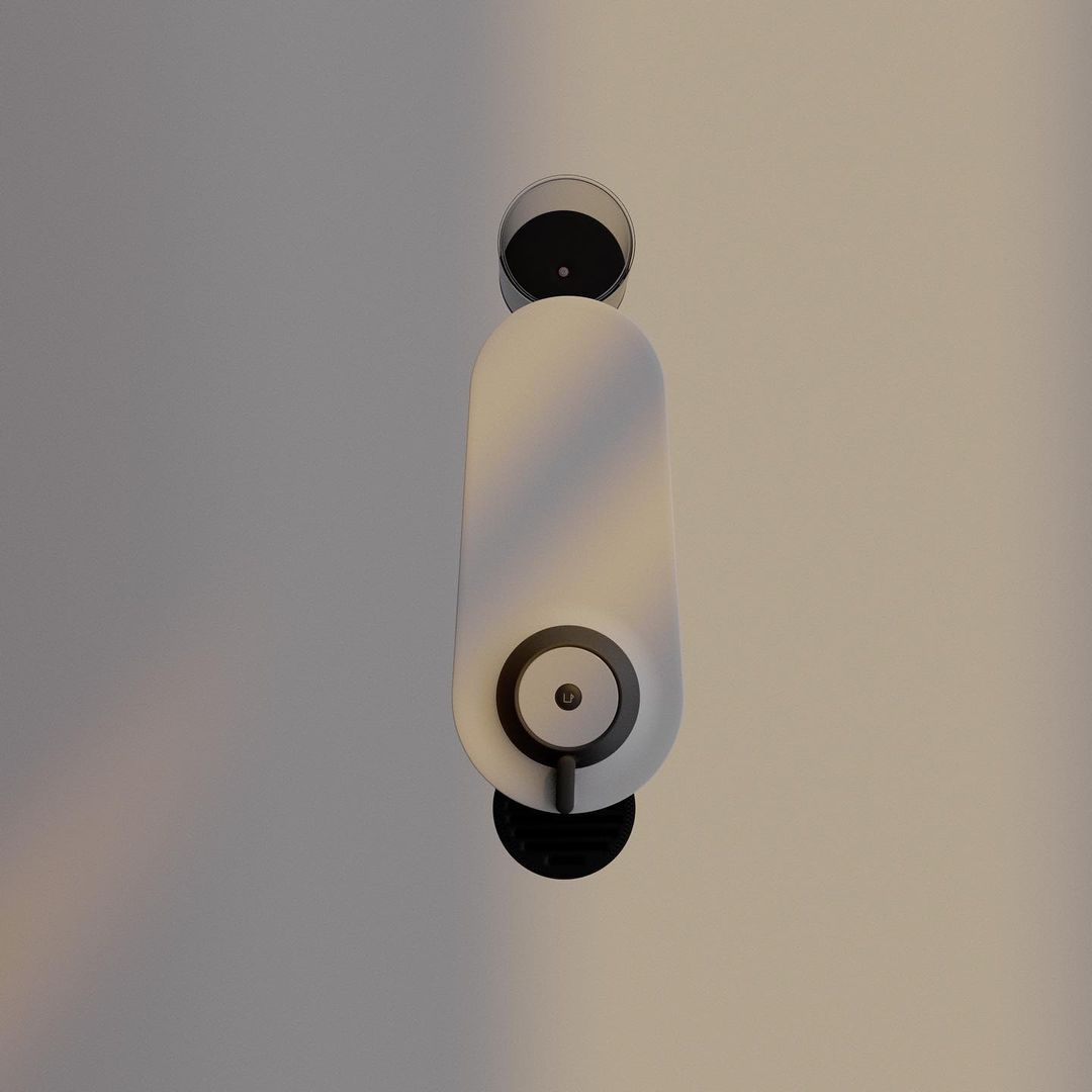Overhead studio shot of a sleek, white, capsule-shaped soap dispenser with black accents against a neutral background.
