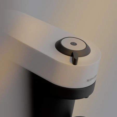White and black Nespresso coffee machine on a neutral background, showcasing its sleek design and functionality for home or office use.