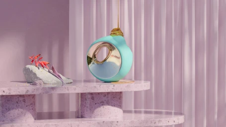 Turquoise and gold sculptural object on a pink speckled terrazzo table with cascading liquid honey and a small grey stone.