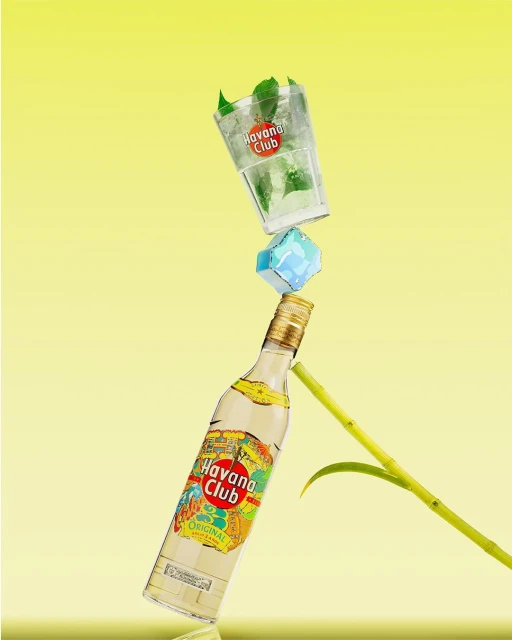 Balanced tower featuring a rum bottle, an ice block, and a mojito glass with mint leaves against a gradient yellow background.