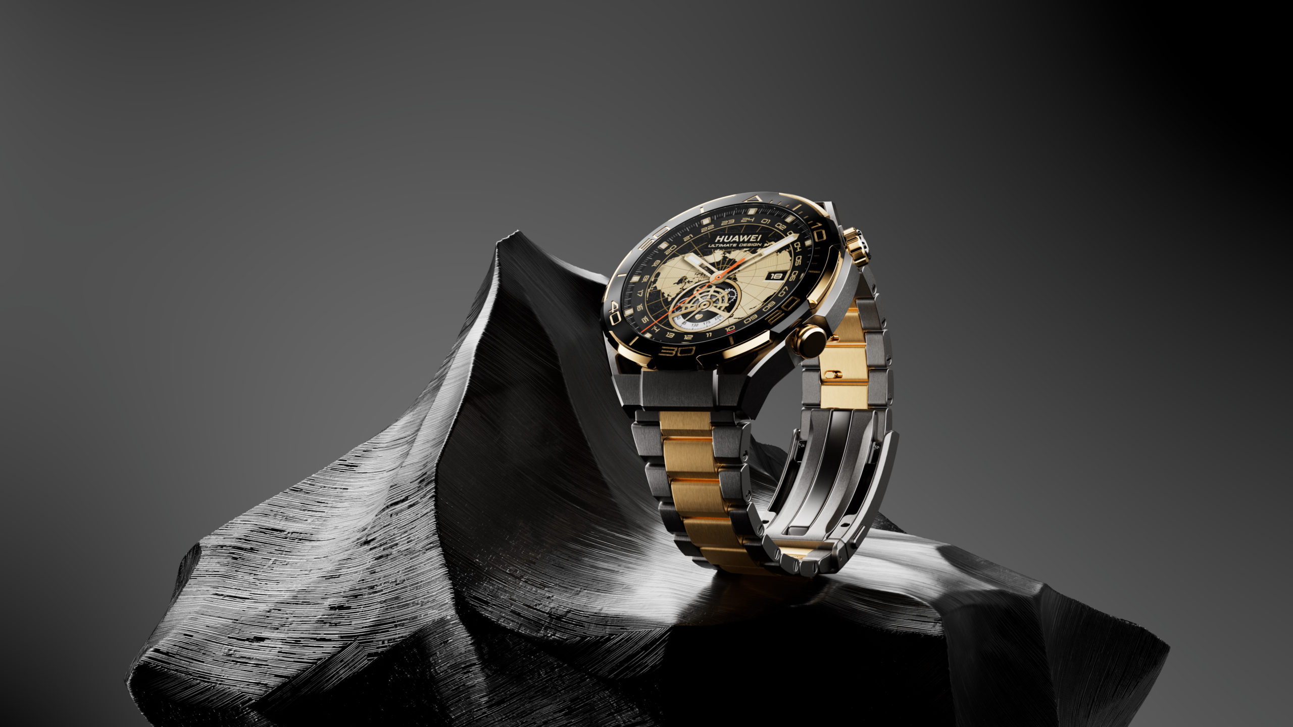 Gold and black Huawei smart watch with world map on display, lying on a textured dark grey platform in front of a grey background.