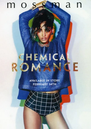 Fashion editorial shot of a woman wearing a shiny blue top and plaid bottoms, against a muted colorful wall with soft, diffused lighting.