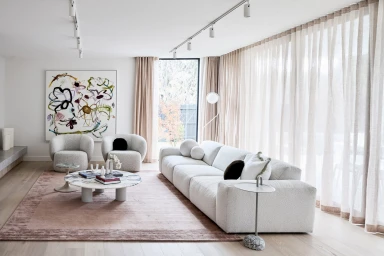 Modern living room interior styled by Aimee Tarulli featuring a white boucle sofa and round marble coffee table
