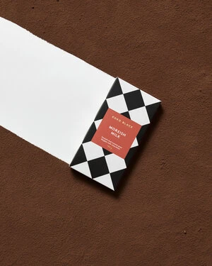 Edco Black Moreish Milk chocolate bar with a black and white diamond pattern on a brown background with a white stripe.