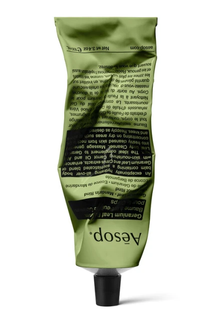 Aesop skincare tube, showcasing the green packaging with black cap against a white background, emphasizing natural beauty product.
