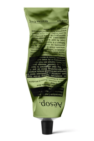 Aesop skincare tube, showcasing the green packaging with black cap against a white background, emphasizing natural beauty product.