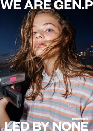 Close-up portrait of a young woman with wet brown hair holding a vintage video camera outdoors at night