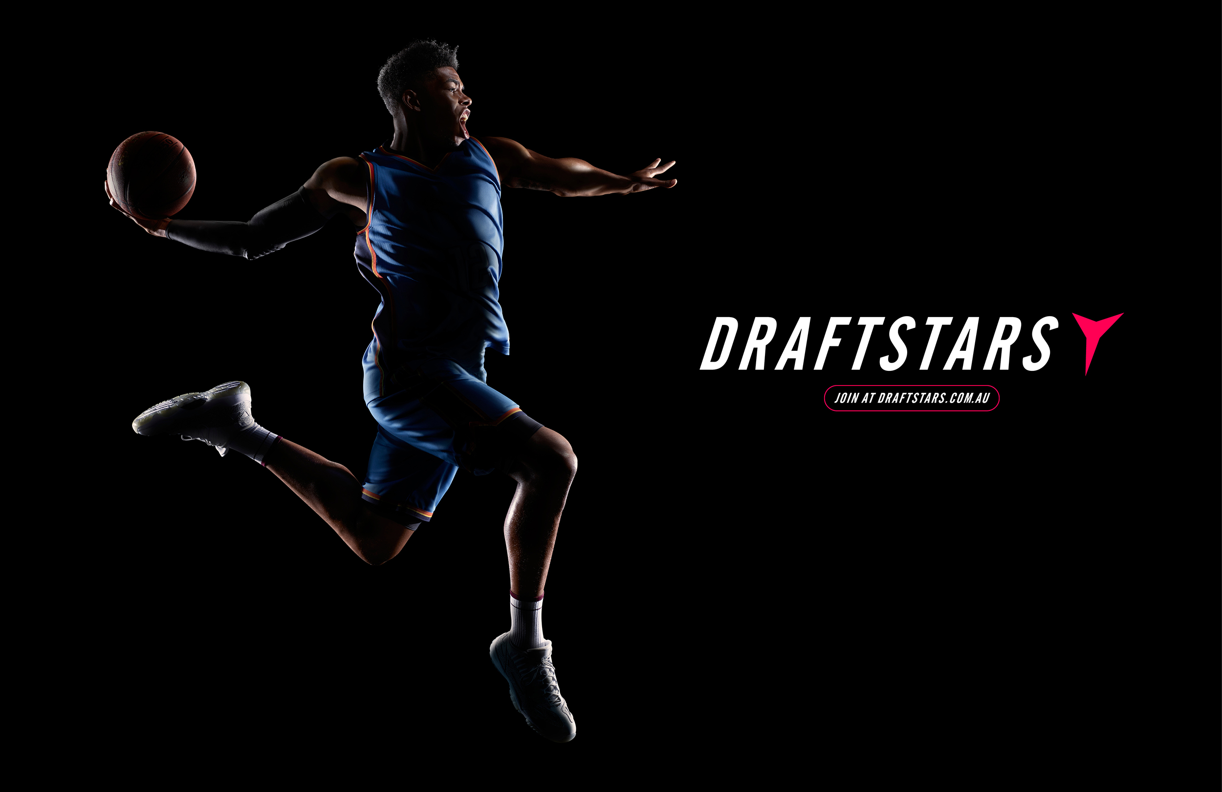 A man in a basketball uniform leaps with a ball against a dark background featuring the Draftstars logo and promotional text.