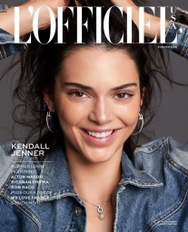 Portrait of Kendall Jenner wearing a denim jacket and silver hoop earrings against a grey background by Russell James.