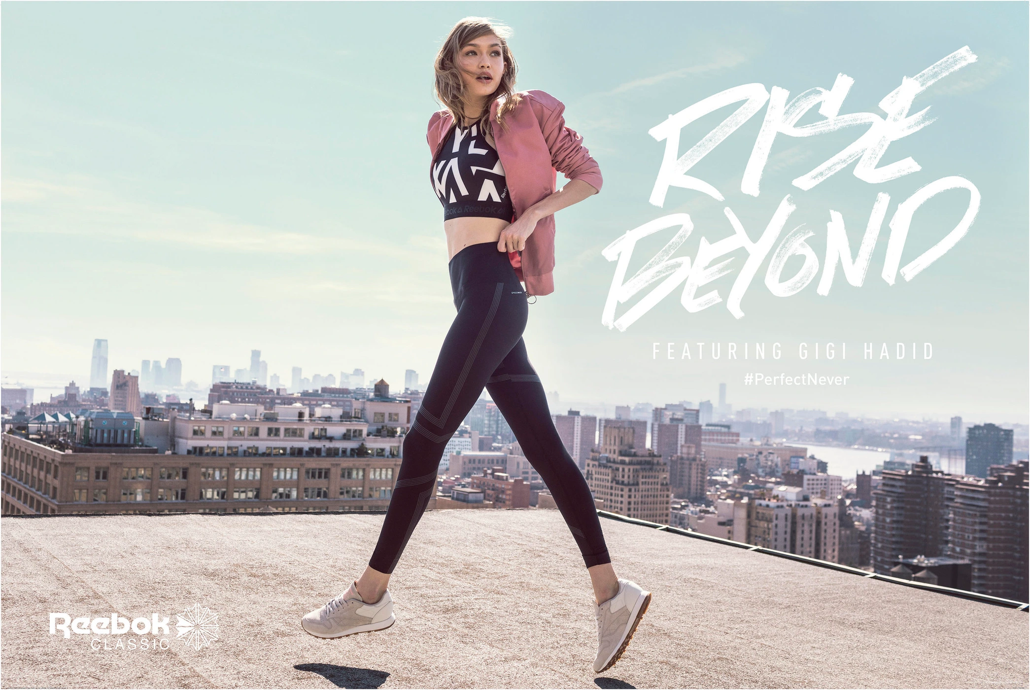 Gigi Hadid wearing athletic apparel while jumping on a city rooftop against a distant skyline
