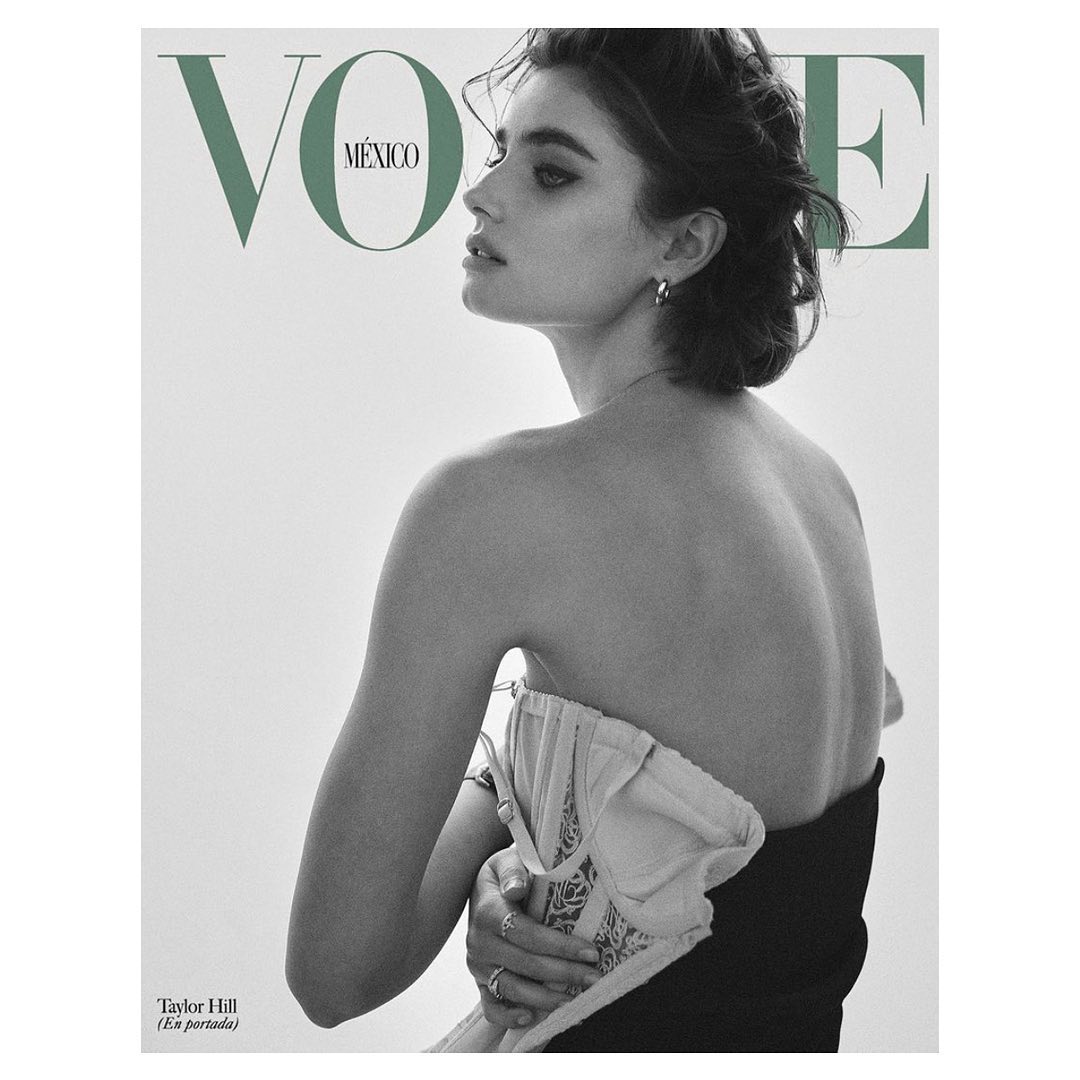 A fashion magazine cover features a fair-skinned woman with dark hair, glancing left over her shoulder. She wears a strapless top against a clean white backdrop.